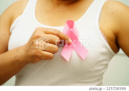 Asian woman with pink ribbon for October world breast cancer day. Asian woman with pink ribbon for October world breast cancer day. 125726599