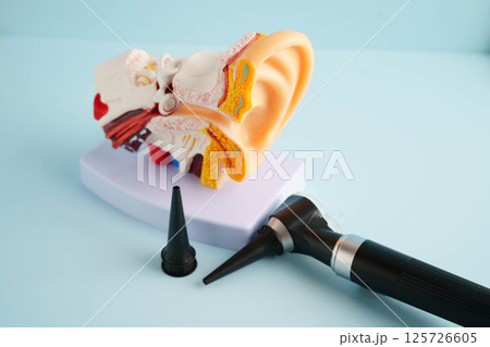 Otoscope with ear model for otolaryngologist or ENT physician doctor examining senior patient ear, hearing loss problem. 125726605