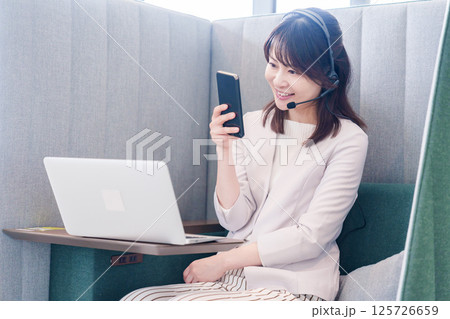 リモート会議をサボってスマホを使う若いビジネスパーソン リモート会議をサボってスマホを使う若いビジネスパーソン 125726659