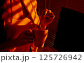 Woman Stirring Drink in Mug under Warm Office Light. 125726942