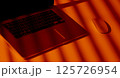 Modern Laptop and Mouse in Dramatic Orange Light. 125726954
