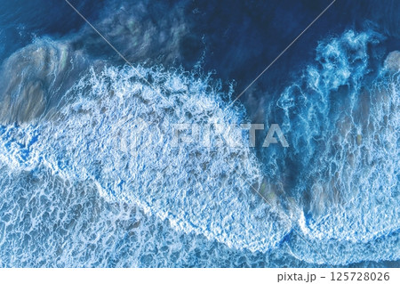 Ocean surf. Waves roll onto the shore. View from above. Natural abstract background 125728026