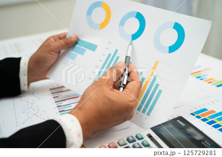Asian business woman working with financial graph. 125729281