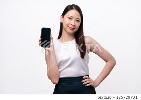 A beautiful Asian businesswoman shows a blank screen of mobile phone. A beautiful Asian businesswoman shows a blank screen of mobile phone. 125729731