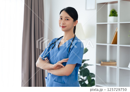 Asian female doctor or nurse standing confidently with stethoscope hanging on her neck Asian female doctor or nurse standing confidently with stethoscope hanging on her neck 125729750