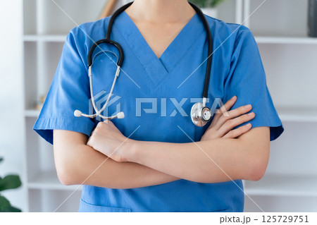 Asian female doctor or nurse standing confidently with stethoscope hanging on her neck Asian female doctor or nurse standing confidently with stethoscope hanging on her neck 125729751