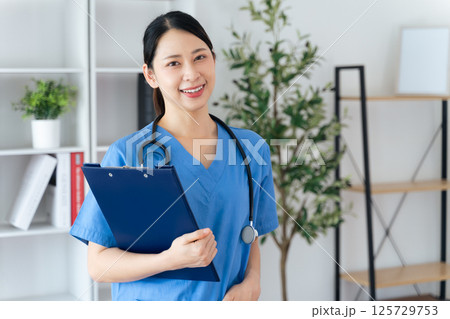 Asian female doctor or nurse standing confidently with stethoscope hanging on her neck Asian female doctor or nurse standing confidently with stethoscope hanging on her neck 125729753