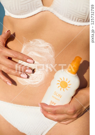 Applying sunscreen lotion on the skin ensures sun protection while enjoying a summer vacation at the beach, promoting healthy skin care practices. Applying sunscreen lotion on the skin ensures sun protection while enjoying a summer vacation at the beach, promoting healthy skin care practices. 125732789
