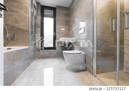 Contemporary bathroom interior with gray tiles, shower, bathtub and tilt and turn window Contemporary bathroom interior with gray tiles, shower, bathtub and tilt and turn window 125733127