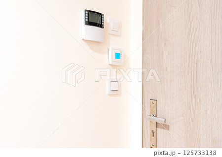 Smart home control panel and thermostat on white wall in modern interior Smart home control panel and thermostat on white wall in modern interior 125733138