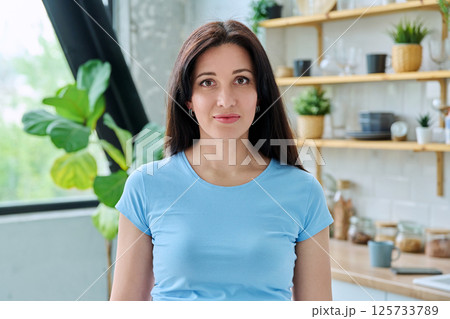 Headshot portrait young smiling woman at home in kitchen 125733789