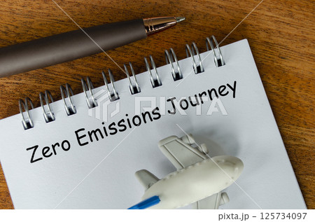 Top view of Zero Emission Journey text on white notepad with small airplane and pen background. Environmental awareness Top view of Zero Emission Journey text on white notepad with small airplane and pen background. Environmental awareness 125734097