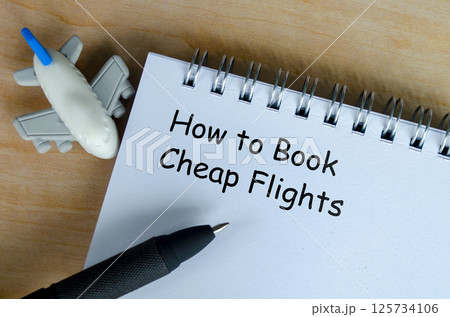 How to book a cheap flights text on white notepad with airplane and black pen background 125734106