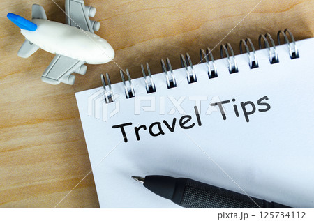 Top view of Travel Tips text on white notepad. Getaway concept. Top view of Travel Tips text on white notepad. Getaway concept. 125734112
