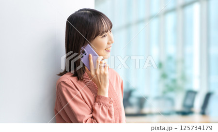 スマートフォンで話す笑顔の女性・ビジネスウーマン 125734179