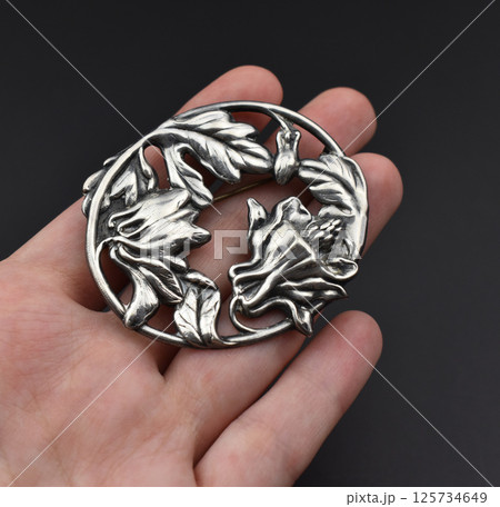 Romantic jewelry brooch with floral charm laid flat 125734649