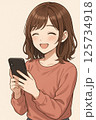 笑顔でスマホを見る若い女性 125734918