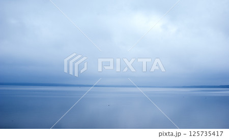 Monochrome minimalist blue landscape, lake merging with the horizon 125735417