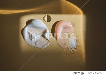 White and pink cream on a beige background. Textures. 125735786