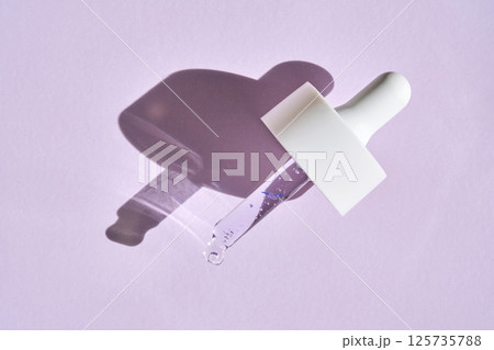 Pipette with serum on purple background with sunlight. 125735788