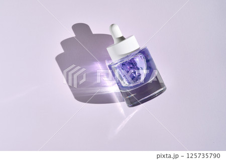 A bottle of face oil for all skin types with cornflower petals. 125735790