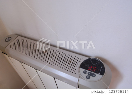 white modern heating knob on high battery mode for heating in apartments and houses. Heating prices. Concept of electricity price increase, electricity saving, reasonable consumption 125736114