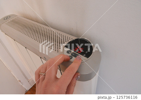 white modern heating knob on high battery mode for heating in apartments and houses. Heating prices. Concept of electricity price increase, electricity saving, reasonable consumption 125736116