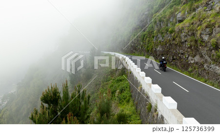 Motorcycle Rider Driving in High Mountain Landscape, Madeira Island , Portugal Motorcycle Rider Driving in High Mountain Landscape, Madeira Island , Portugal 125736399