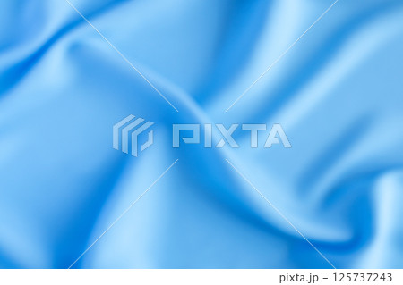Abstract blurred blue fabric texture with smooth flowing folds 125737243