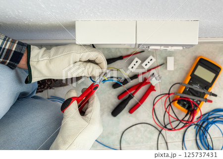 Electrician at work on a residential electrical system. Electricity.  125737431
