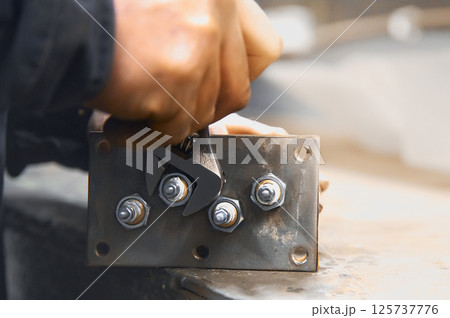 Human hand holding a wrench on a nut with shallow depth of field Human hand holding a wrench on a nut with shallow depth of field 125737776
