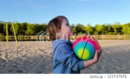 bonding time with family. Happy family in nature. Family ball game fun outdoors. Father and young child enjoy playing with colorful ball in park. Father and son play with a ball on the beach bonding time with family. Happy family in nature. Family ball game fun outdoors. Father and young child enjoy playing with colorful ball in park. Father and son play with a ball on the beach 125737976