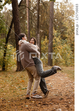 Happy couple embracing in autumn forest Happy couple embracing in autumn forest 125738083