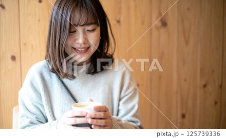 木目カフェで微笑む日本人女性 125739336