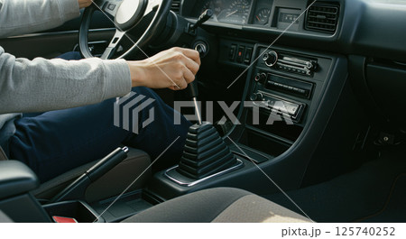 マニュアル車を運転する男性の手元 125740252