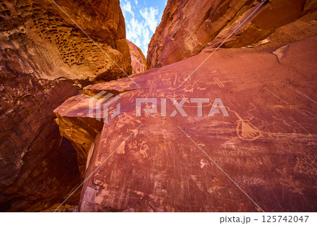 Ancient Petroglyphs on Red Sandstone Cliffs with Upward Perspective Ancient Petroglyphs on Red Sandstone Cliffs with Upward Perspective 125742047
