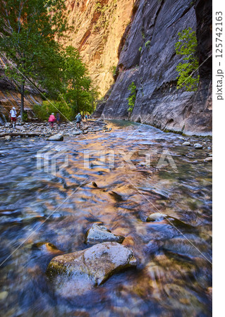 Hikers Exploring Zion Narrows at Golden Hour Eye Level Perspective 125742163