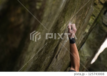 ロッククライミングで岩を握る男 125743008