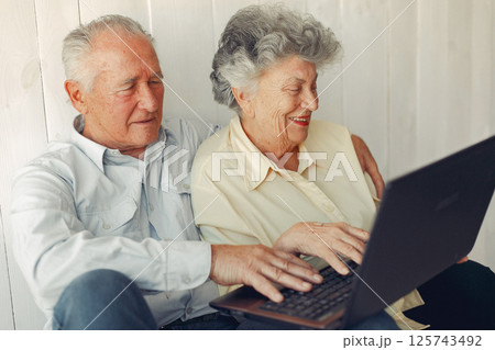 Grandparents at home. Old people use the laptop. Senior in a blue shirt. Grandparents at home. Old people use the laptop. Senior in a blue shirt. 125743492