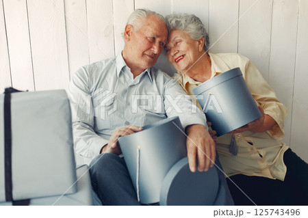 Grandparents at home. Old people with presents. Senior in a blue shirt. Grandparents at home. Old people with presents. Senior in a blue shirt. 125743496