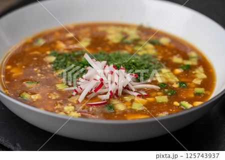Chilled Russian summer soup featuring kvass, diced vegetables, chopped herbs, boiled meat, garnished with radish slices Chilled Russian summer soup featuring kvass, diced vegetables, chopped herbs, boiled meat, garnished with radish slices 125743937