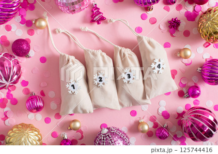 Christmas advent calendar with gift velvet bags on a pink background. Environmentally friendly. 125744416