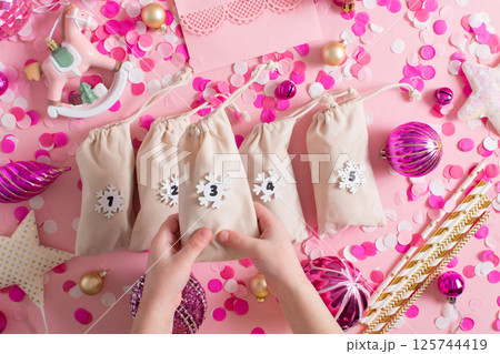 Christmas advent calendar with gift velvet bags on a pink background. Environmentally friendly. 125744419