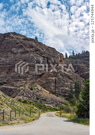 Gated gravel road leading to the mounain area in Canada. Vertical panorama 125744944