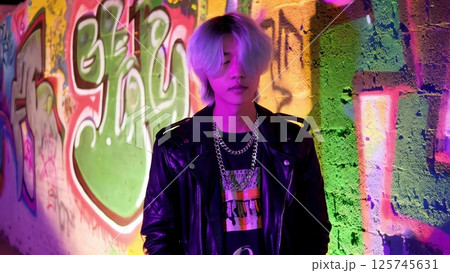 Young rapper posing in front of graffiti wall 125745631