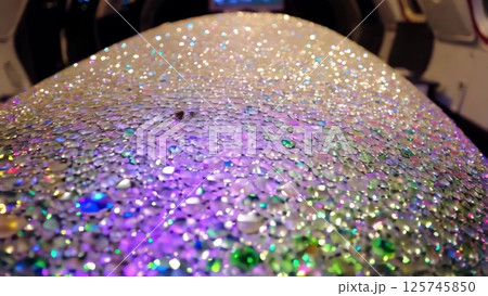 Colorful water drops glistening on a curved surface 125745850