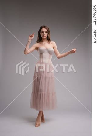 Elegant woman in a corset and tulle skirt showcasing contemporary fashion 125746650