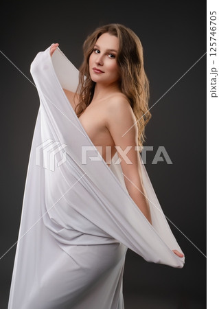 Pregnant woman showcasing beauty with flowing drapery in studio lighting Pregnant woman showcasing beauty with flowing drapery in studio lighting 125746705
