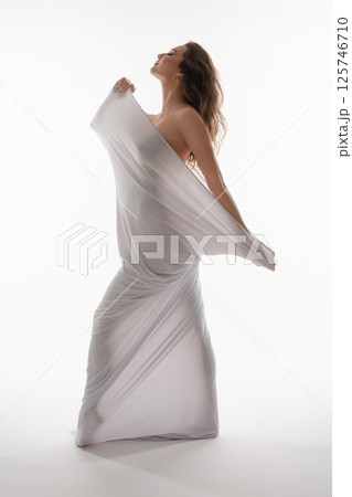 Pregnant woman in elegant white draping posing gracefully with beauty Pregnant woman in elegant white draping posing gracefully with beauty 125746710