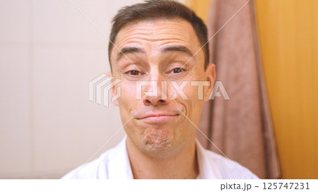 Good natured man making funny face in bathroom 125747231
